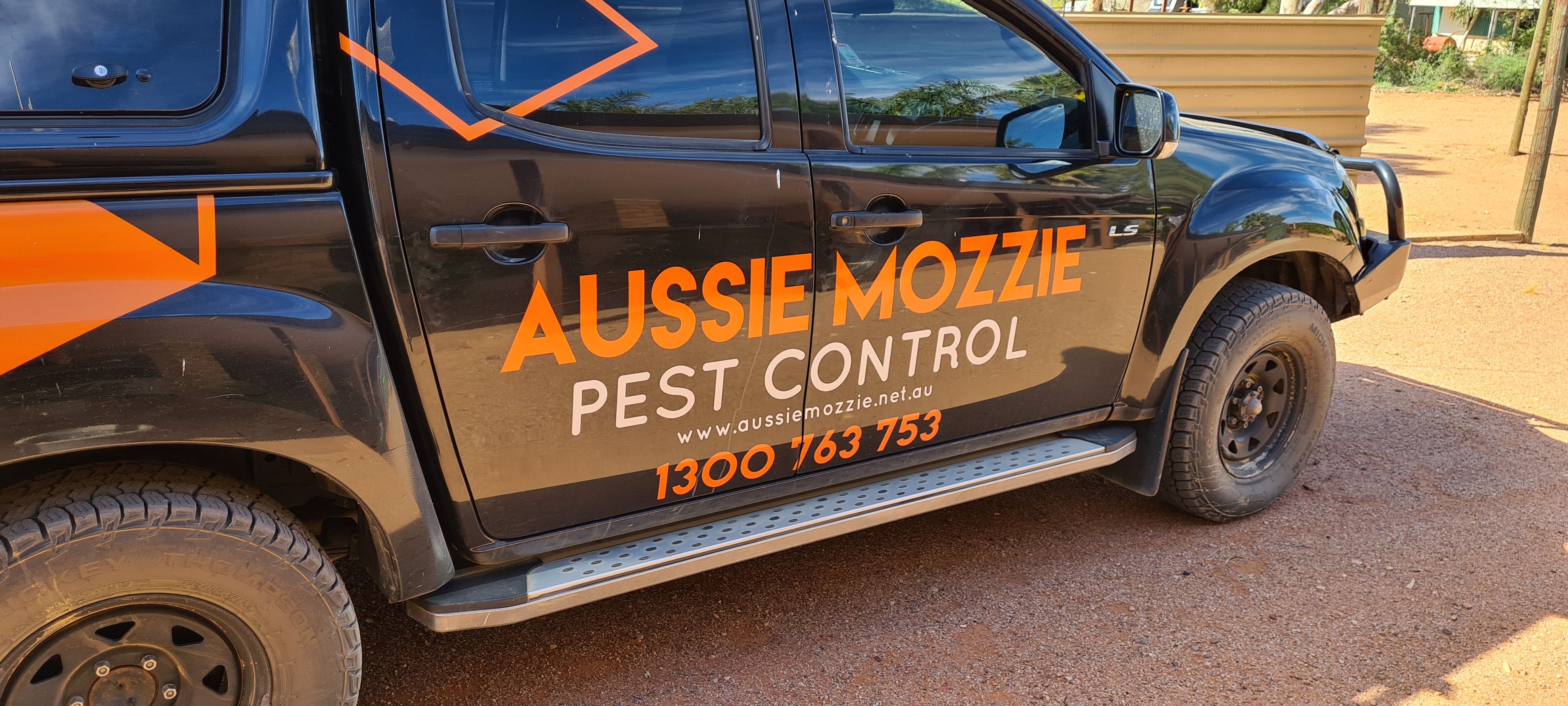 The black Aussie Mozzie ute with the orange logo and phone number on the door
